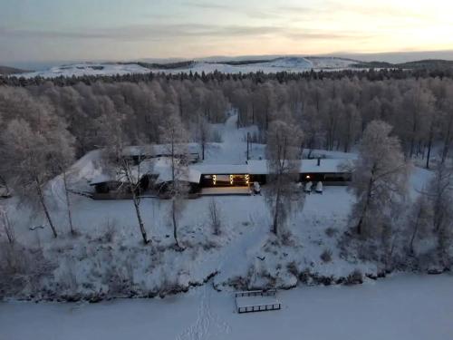 an aerial view of a house in the snow at Private log villa by the Ivalo River in Ivalo