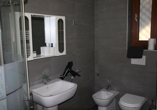 ein Badezimmer mit Waschbecken und Toilette in der Unterkunft Melzo INN in Melzo