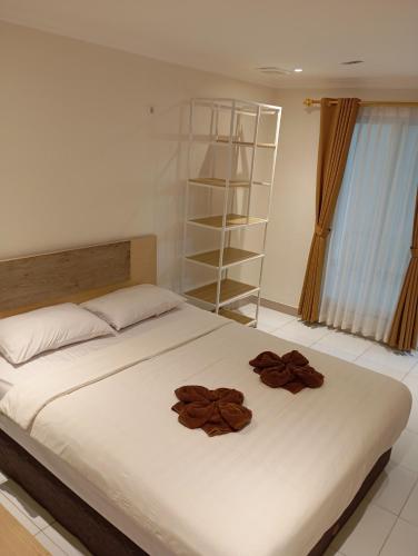 a bed with two brown flowers on top of it at Hotel Paris Santika in Rawara