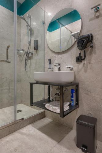 a bathroom with a sink and a shower and a mirror at City Line HOTEL in Astana