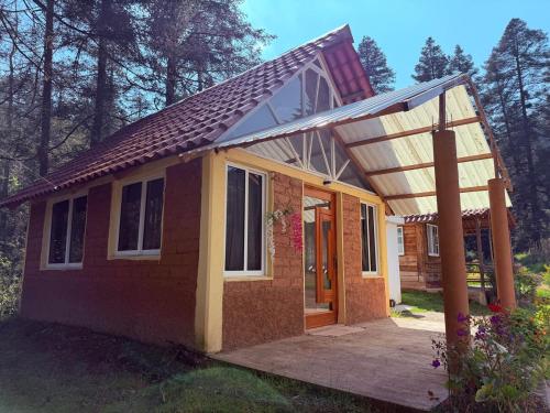 a small house with a roof and a porch at Cabañas D Güereo By GEstores in Mineral del Chico