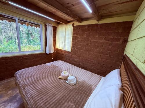 a small room with a bed with two dolls on it at Cabañas D Güereo By GEstores in Mineral del Chico