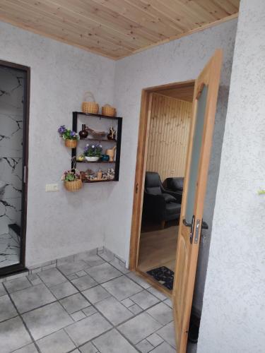 a room with a door open to a room with a chair at Sun ray in Ch'ik'unet'i