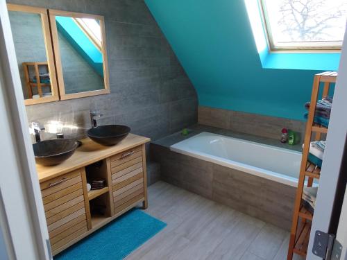 La salle de bains est pourvue de 2 lavabos et d'une baignoire. dans l'établissement Archipel Holiday Cottage, à Ellezelles