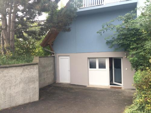 a blue building with two white doors and trees at B&B chez Didier et Catherine in Ittenheim