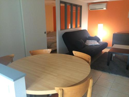 a living room with a wooden table and a couch at B&B chez Didier et Catherine in Ittenheim