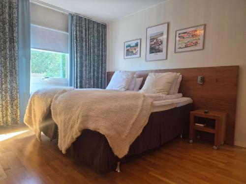 a bedroom with a bed with a blanket on it at Hotell Åsen in Anderstorp