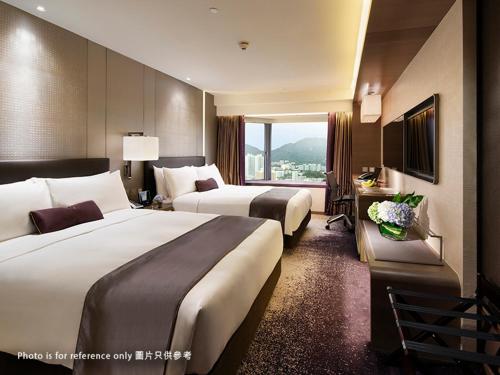 a hotel room with two beds and a window at Royal Plaza Hotel in Hong Kong