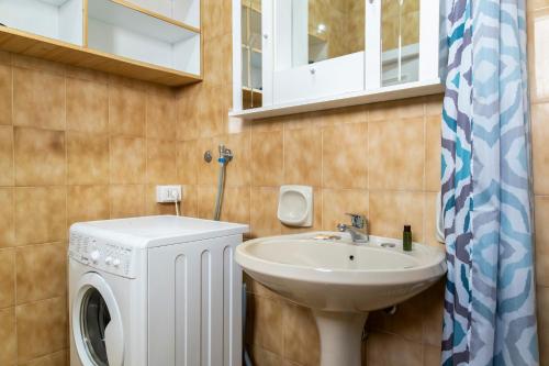a bathroom with a sink and a washing machine at Appartamento Sunny by ThePuglia in Torre Lapillo