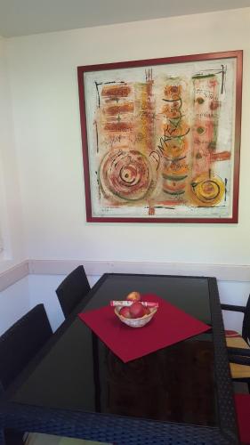 a table with a bowl of fruit and a painting on the wall at Ferienwohnung Suter in Seewen