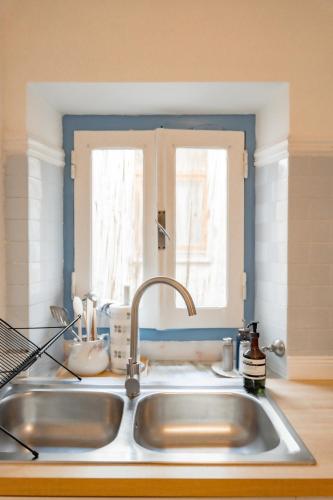 a kitchen counter with a sink and a window at Inderooms Carloforte in Carloforte