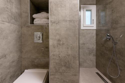a bathroom with a shower and a toilet at Olea Mare Suites in Koinyra