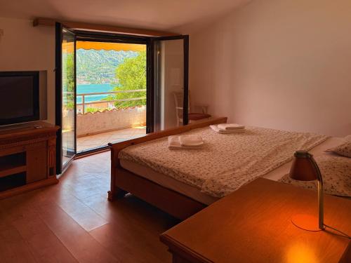 a bedroom with a bed and a sliding glass door at Villa Four-bedroom Prcan Kotor in Prčanj