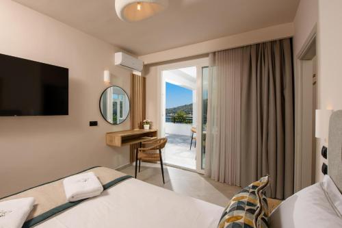a hotel room with a bed and a desk and a window at Olea Mare Suites in Koinyra