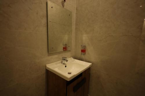 a bathroom with a sink and a mirror at L Roy in Meerut