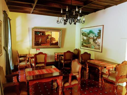 uma sala de jantar com mesas e cadeiras e um lustre em Casa Carmel Bed & Breakfast em Guatemala