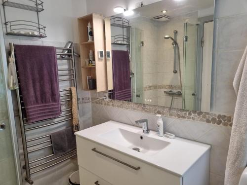 a bathroom with a sink and a shower with purple towels at Bed and Breakfast Birkerod in Birkerød