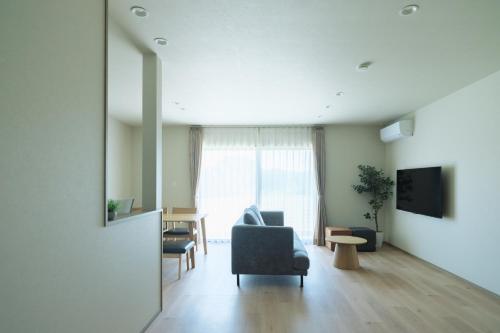 a living room with a chair and a television at Green Peak 2 in Aso