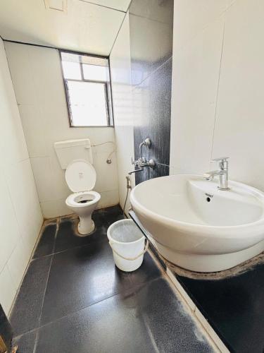 a bathroom with a sink and a toilet at Sun N Shine in Pune
