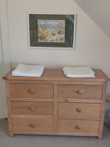 a wooden dresser with two towels on top of it at Aberlour Cottages - Bolthole & Retreat in Aberlour