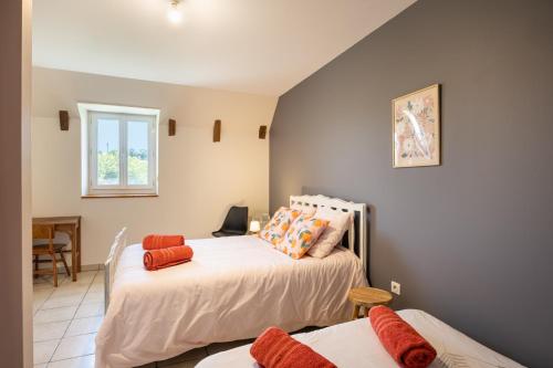 a bedroom with two beds and a table at Gite Le Ginestou in Almon-les-Junies