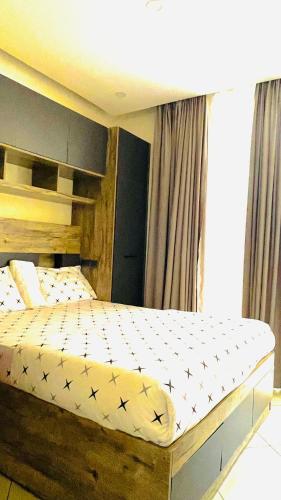 a bedroom with a bed with a wooden frame at AGASARO LUXURY Apartment in Kigali