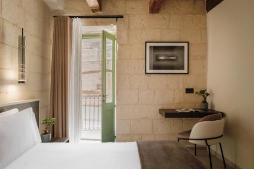a bedroom with a bed and a desk and a window at Casa Radiant in Rabat