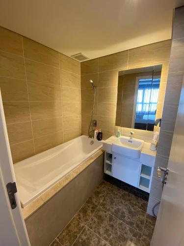 a bathroom with a tub and a sink at Vinhomes D'Capitale - Amee Apartment in Hanoi