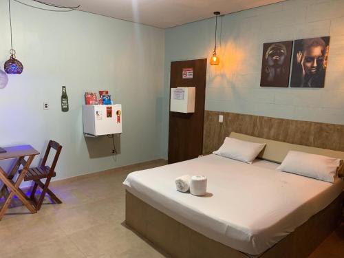 a bedroom with a bed and a desk and a table at Rota 69 motel in Porto Nacional