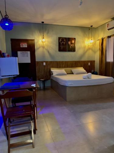 a bedroom with a bed and a chair and a table at Rota 69 motel in Porto Nacional