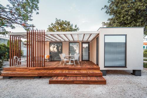 a house with a wooden deck with a table at Modern Seaside House in Pakoštane