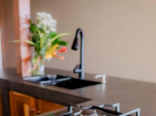 a vase of flowers on a counter with a sink at Blue Beach Villa - Nilwella in Matara