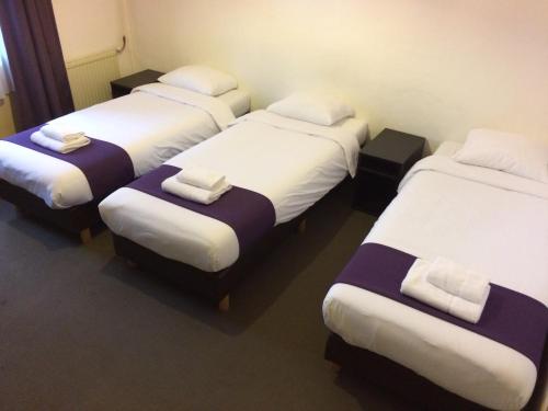 a group of four beds in a room at Hotel Bellington in Amsterdam