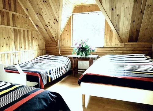 a bedroom with two beds and a window at Kryzbarkas in Degučiai