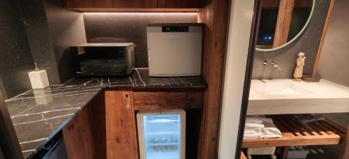 a small kitchen with a sink and a microwave at 忘寂民宿 in Zhangjiajie
