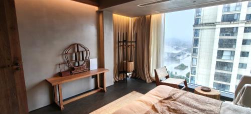a bedroom with a bed and a large window at 忘寂民宿 in Zhangjiajie