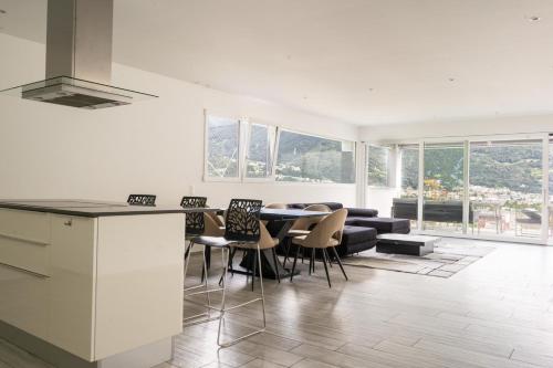 a kitchen and living room with a table and chairs at Villa Sementina - Luxury Stay with Pool and Gym - 15 m to Lake Maggiore in Bellinzona