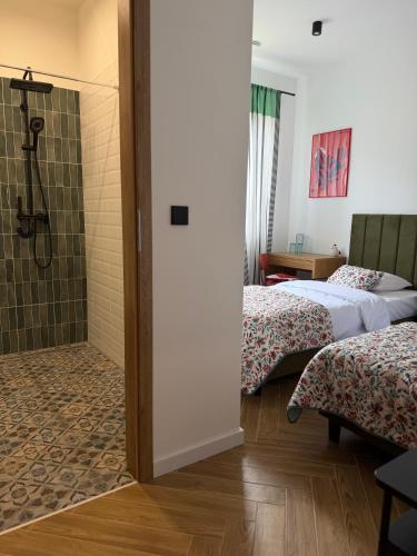 a bathroom with two beds and a shower at Szumi Las Bed & Breakfast in Józefów