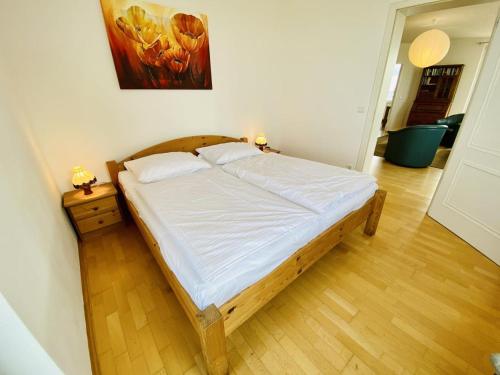 a large bed in a room with a wooden floor at Marthes Seeblick in Warnemünde