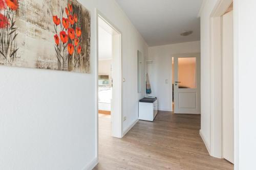 a hallway with a painting of red flowers on the wall at Haus Leuchtfeuer/Eagle in Warnemünde