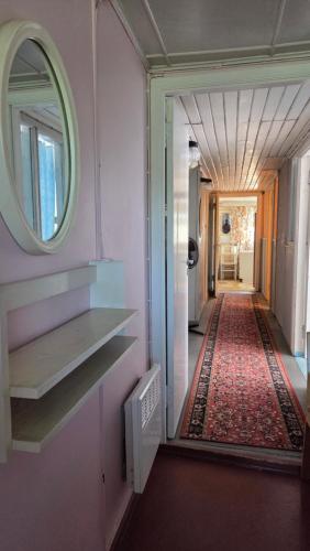 a hallway with a mirror on the wall and a hallway with a rug at Aliise Garden Guesthause in Pärnu