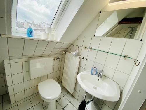 a small bathroom with a toilet and a sink at Kapitänshaus in Warnemünde