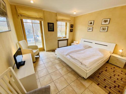 a bedroom with a bed and a desk and chairs at Captains Lounge in Warnemünde