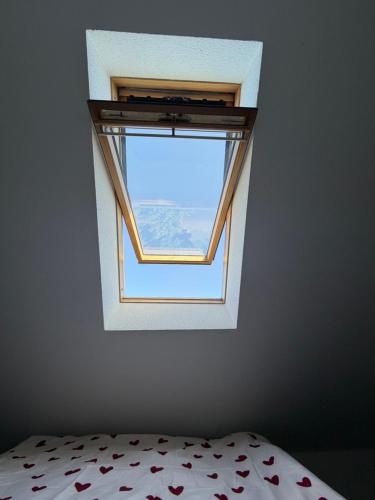 a small window in a room with a bed at Exklusives Dach-Loft Helles Wohnerlebnis in Elmshorn