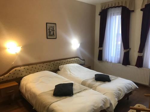 two beds in a hotel room with towels on them at Thermal Apartman 01 in Kiskőrös