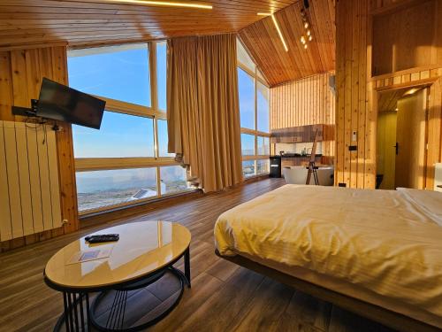 a bedroom with a bed and a table with a television at O Sommet in Zaarour