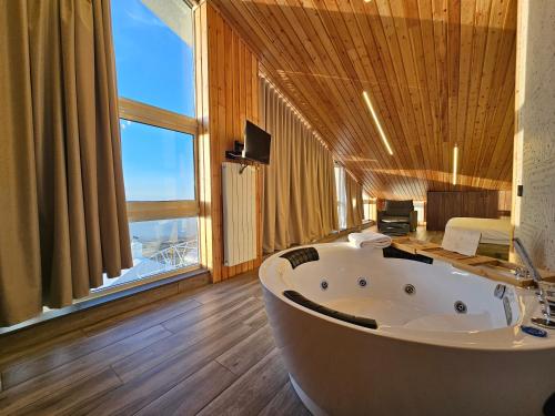 a bath tub in a room with a large window at O Sommet in Zaarour