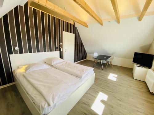 a bedroom with a white bed and a television at Ferienhaus Viewpoint in Warnemünde