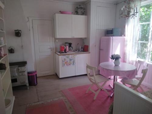 a kitchen with a table and a white refrigerator at Ruissalo Cottage in Turku