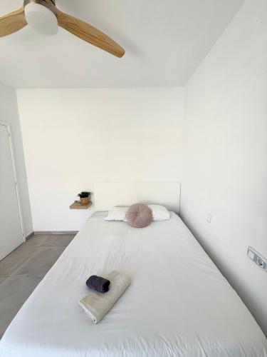 a bedroom with a white bed with two towels on it at Cisne By Nest Hostel in San Antonio